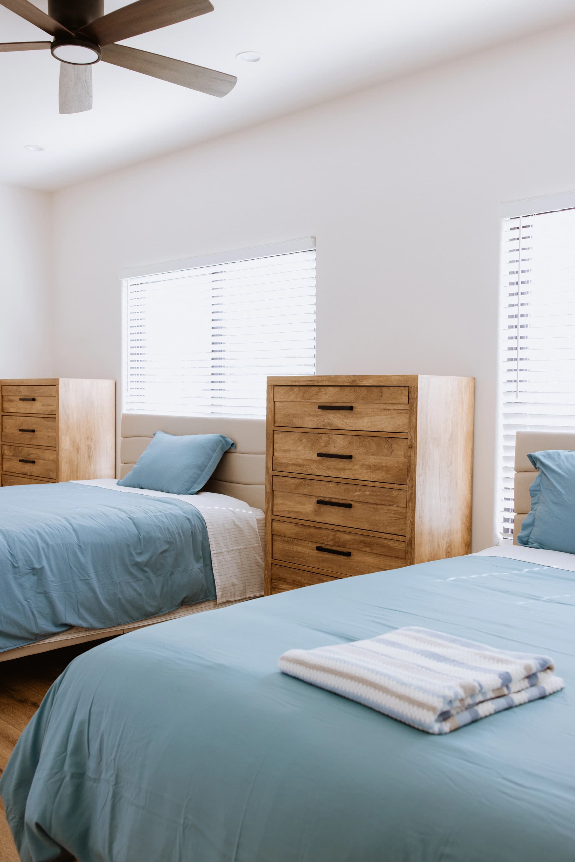 Client bedroom with two beds and wooden dressers